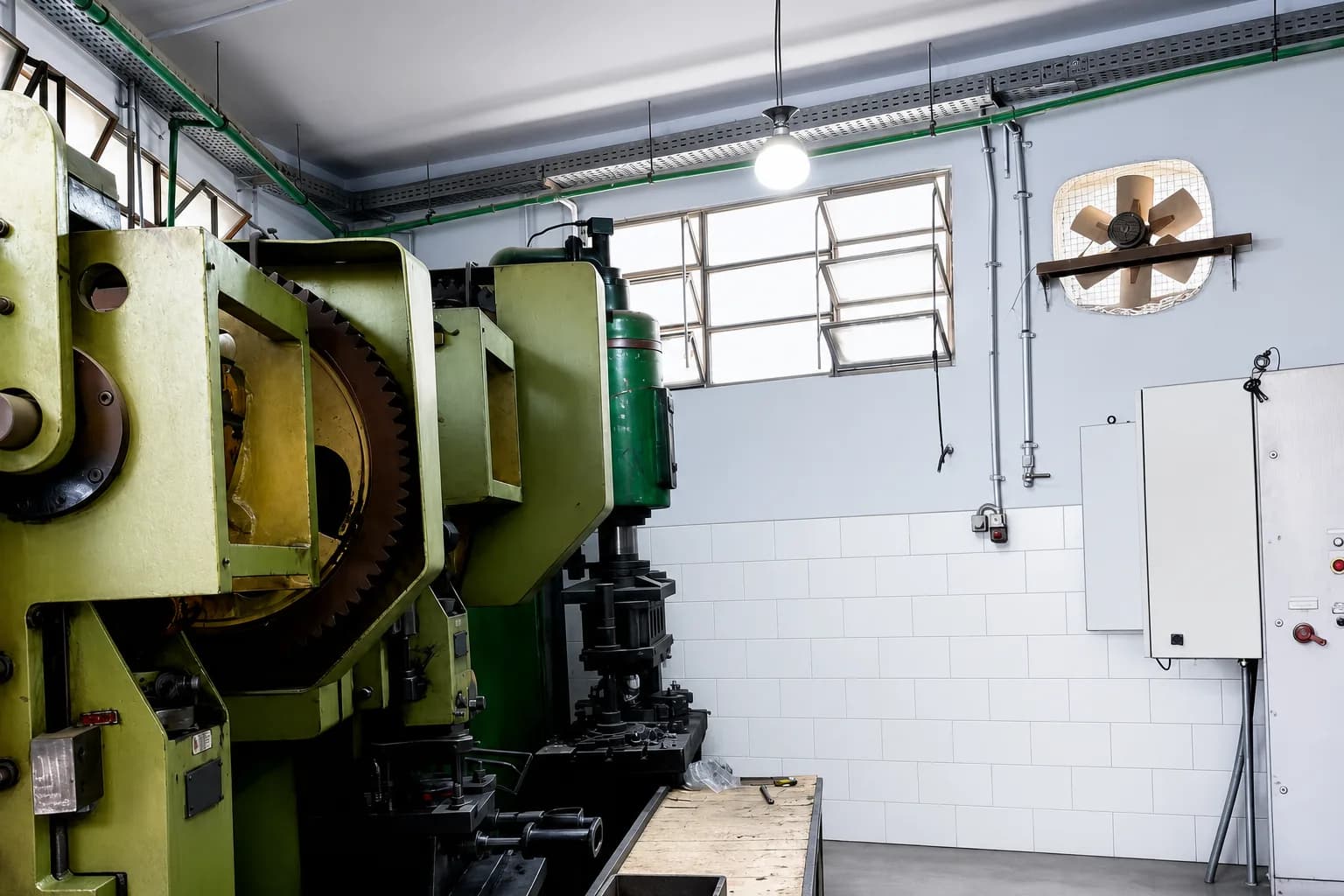 Stamping presses along a tiled workshop bay